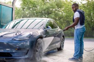 Driver washing an electric car